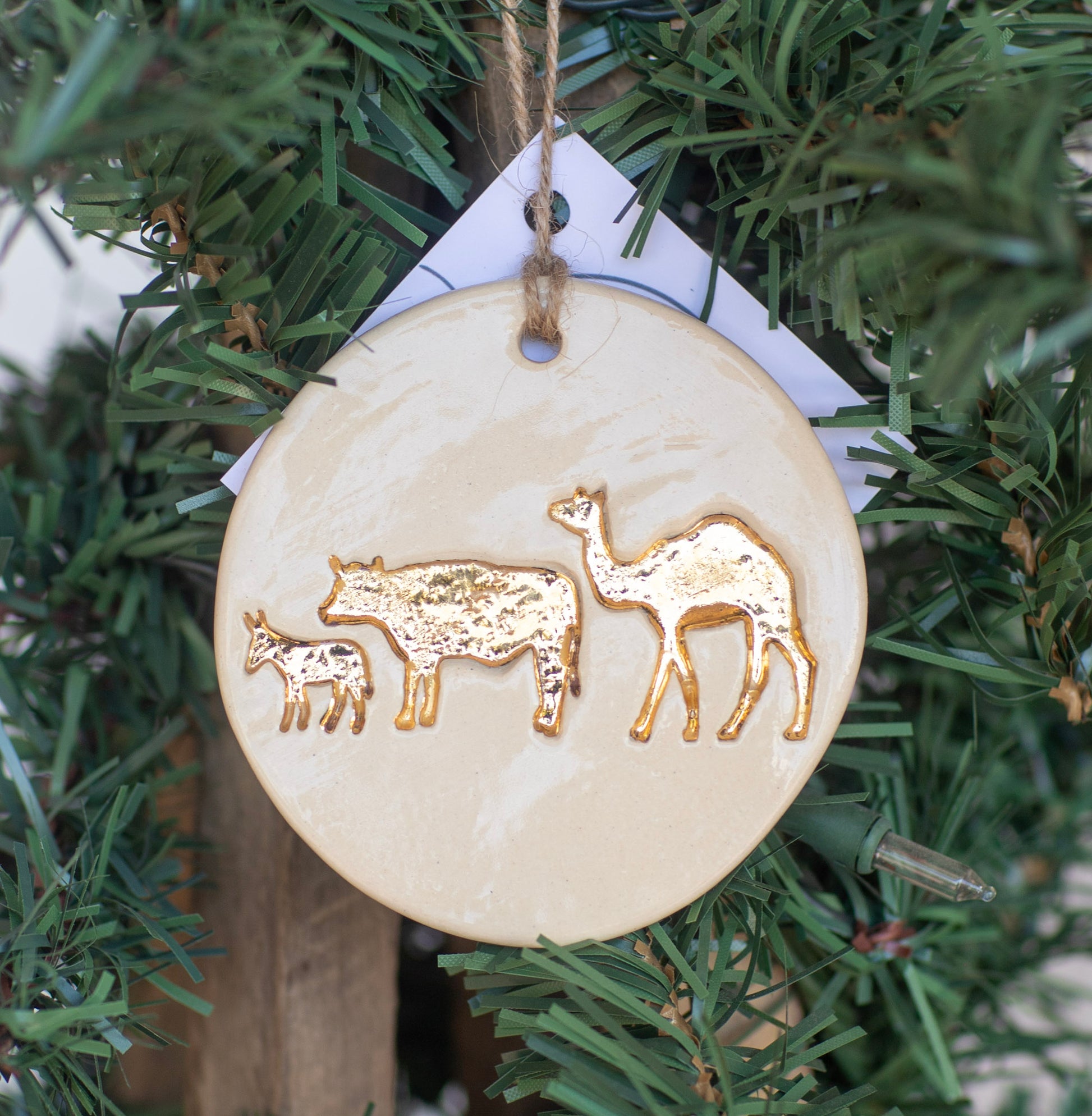 Decorative ornament with gold animal illustrations on a Christmas tree.